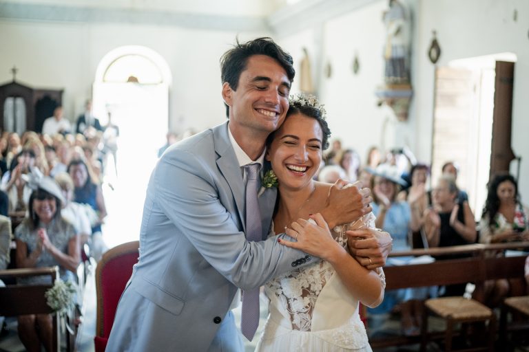 Couple de mariée souriant se tenant dans les bras dans une église