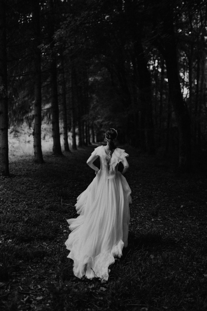 Mariée Maison Jasmée Anaïs. Elle est de dos est court dans une forêt;