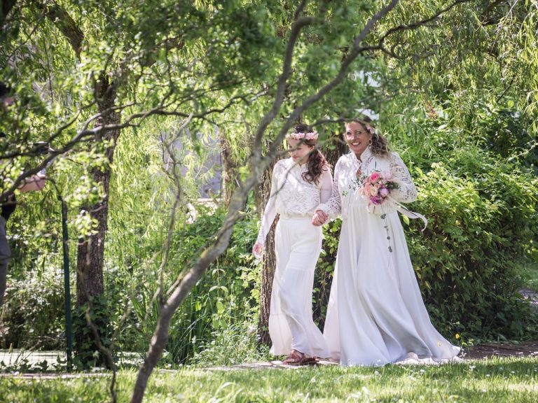 Mariée accompagnée de sa fille, celle-ci s'avance un bouquet à la main vers le lieu de son mariage