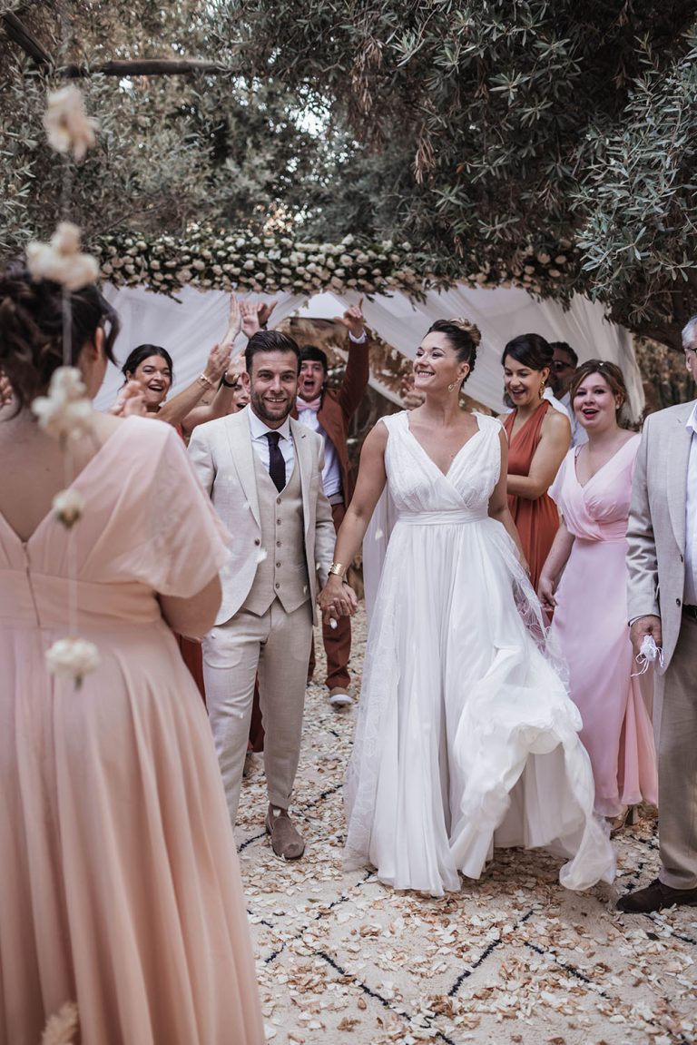 Couple de mariés au centre de leurs invités.