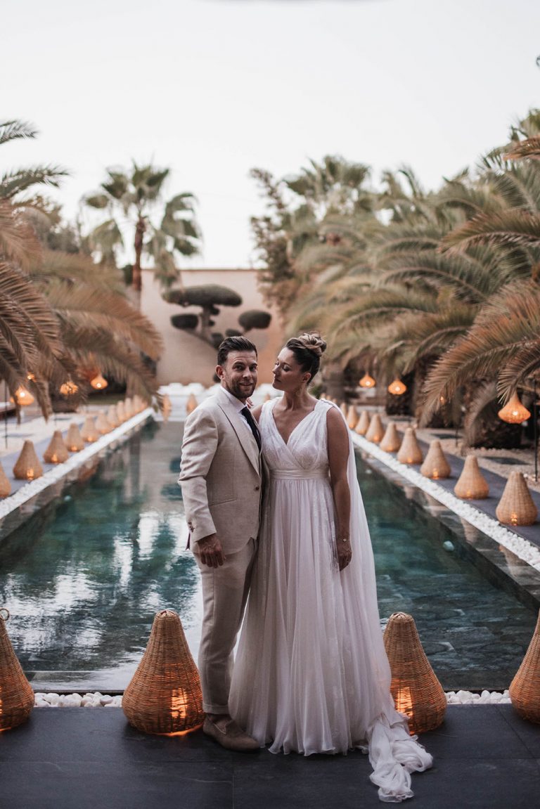 Couple debout devant une piscine