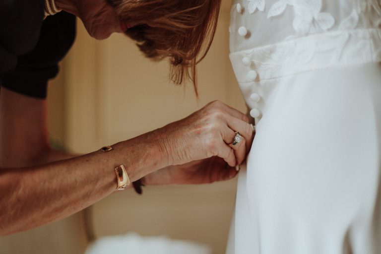 Mère d'une mariée boutonnant le dos de sa robe