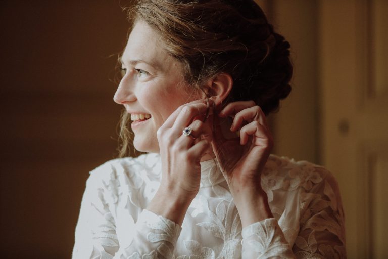 Mariée mettant une boucle d'oreille.