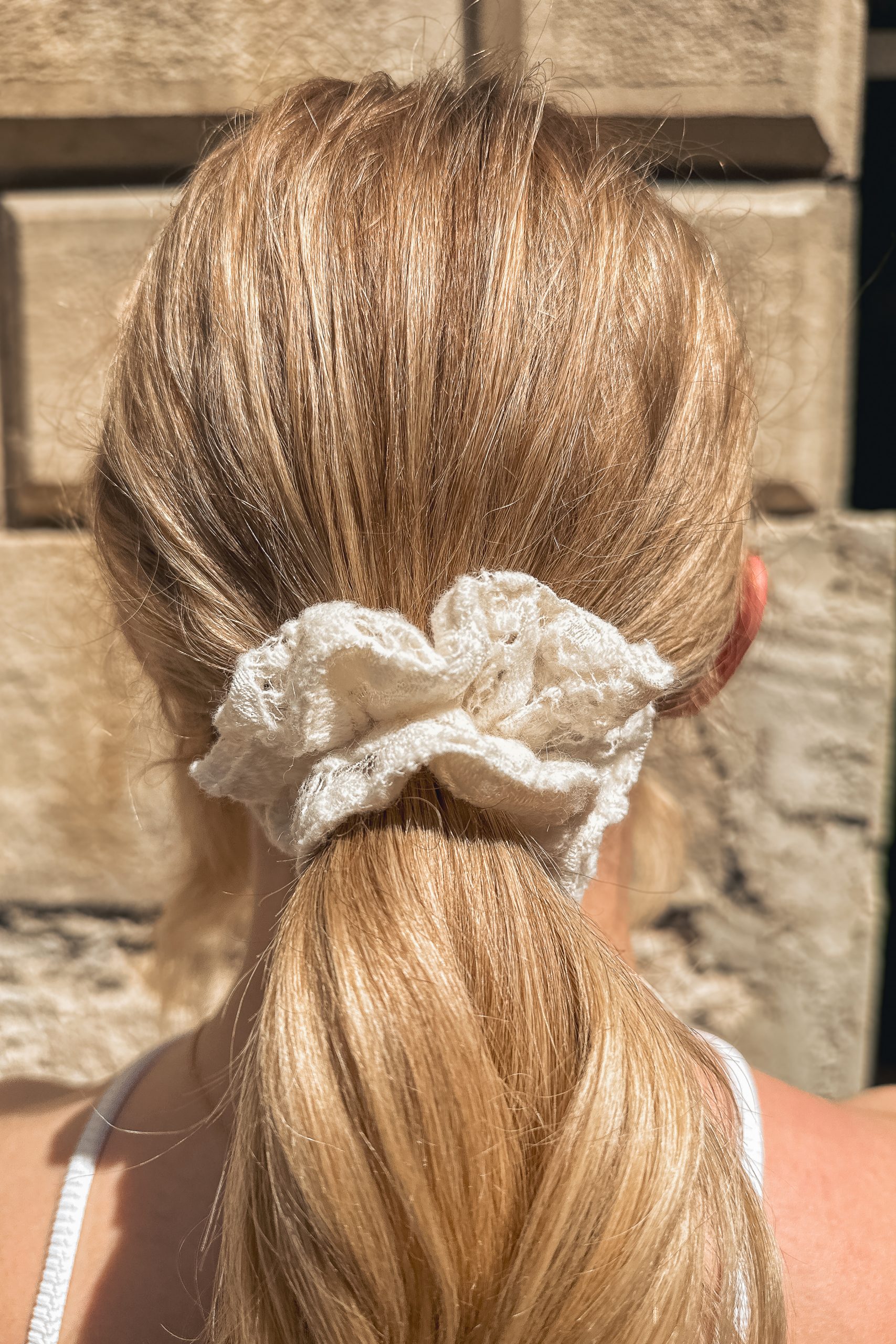 Chouchou petit modèle en dentelle de laine porté par une femme de dos