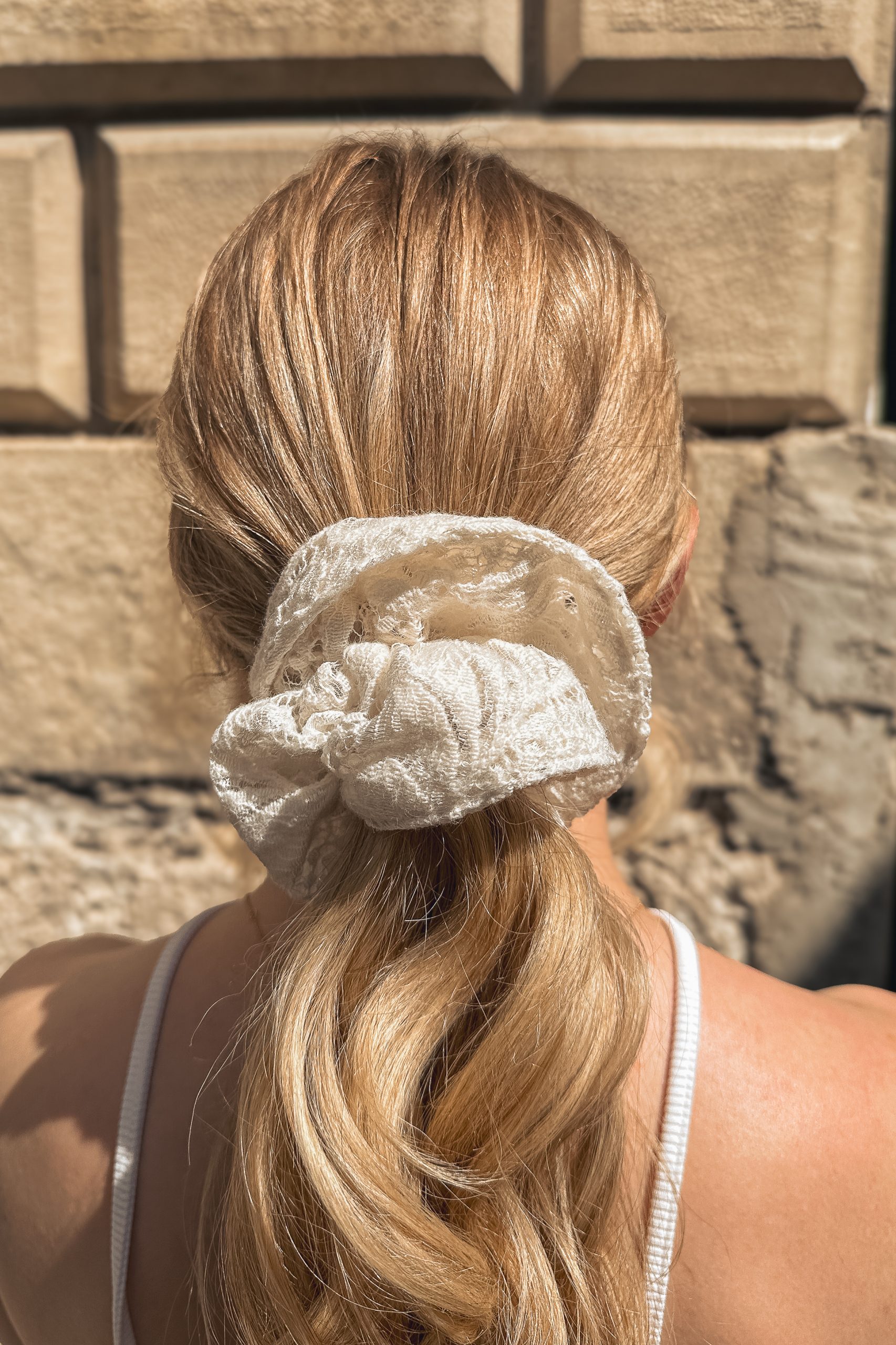 Chouchou grand modèle en dentelle de laine porté par une femme de dos