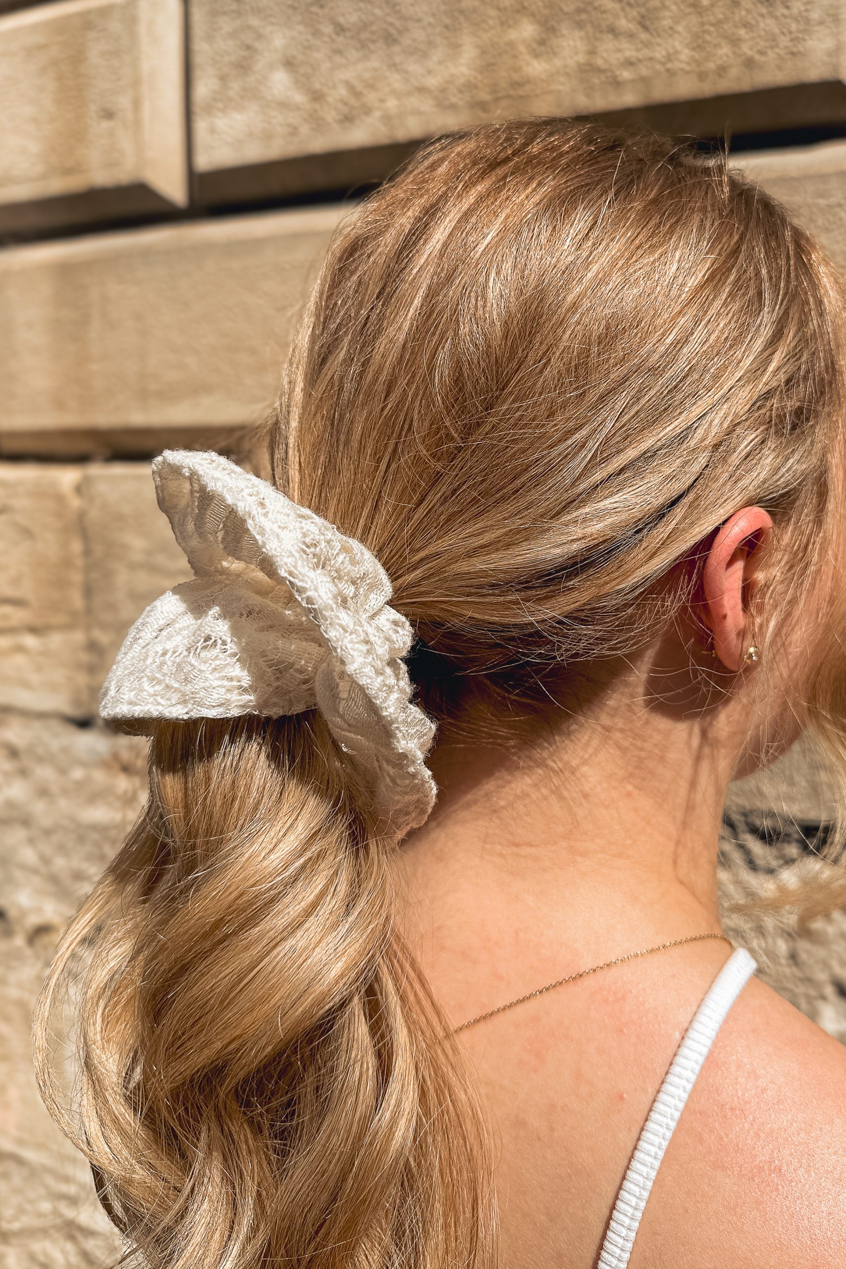 Chouchou grand modèle en dentelle de laine porté par une femme de profil