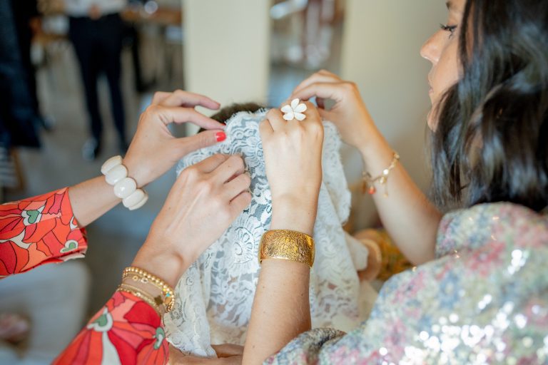 Famille de la mariée l'aidant à mettre son voile.
