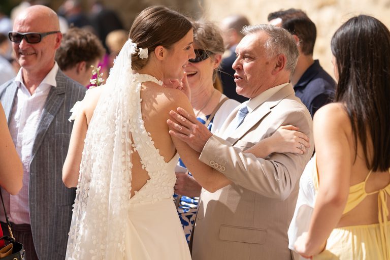 Mariée embrassant un invité à la sortie de l'église.