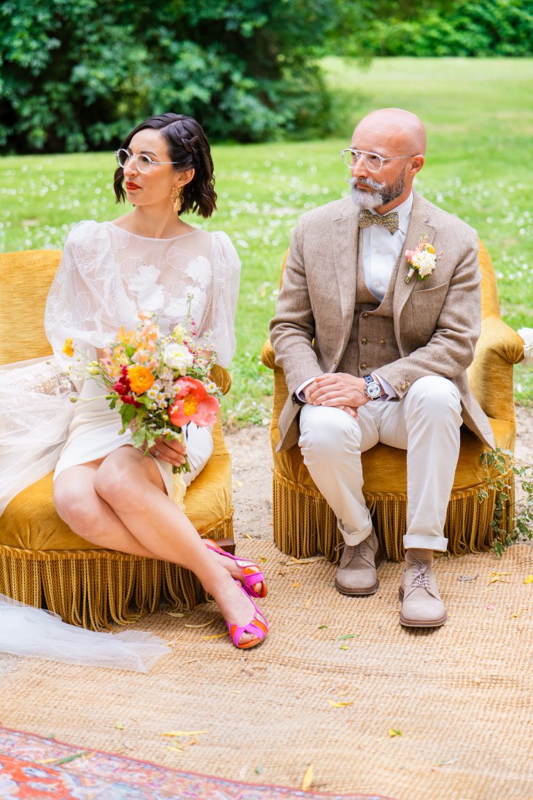 Couple de mariés écoutant attentivement l'officiante de cérémonie.