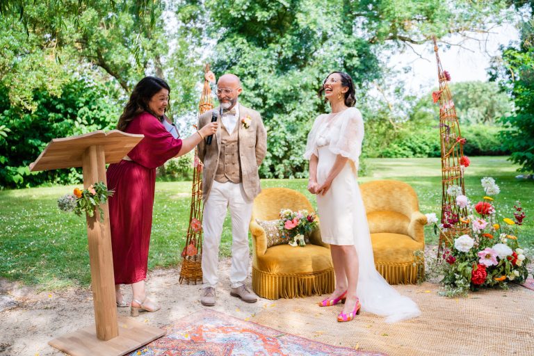 Couple de mariés en compagnie de l'officiante de cérémonie laïque.