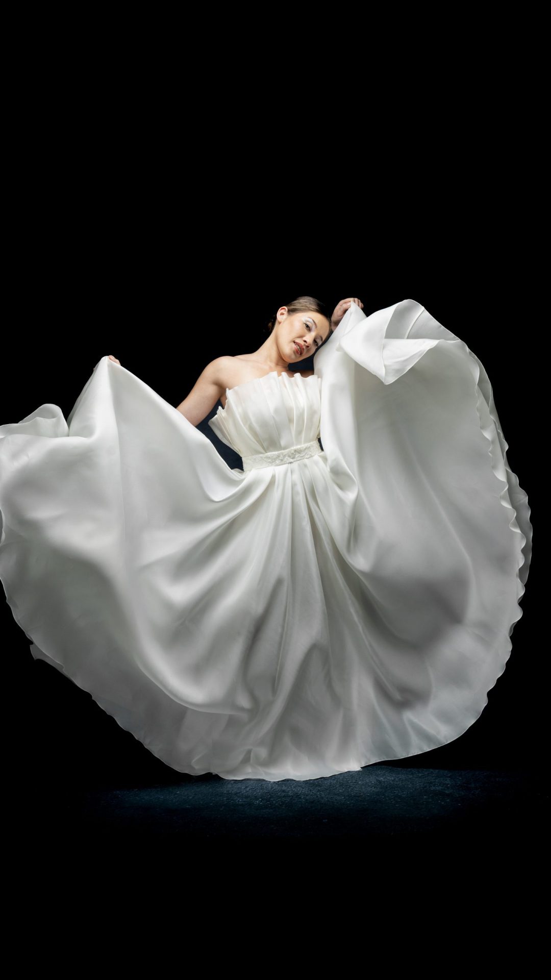 Femme en robe de mariée sur mesure Maison Jasmée qui joue avec sa robe