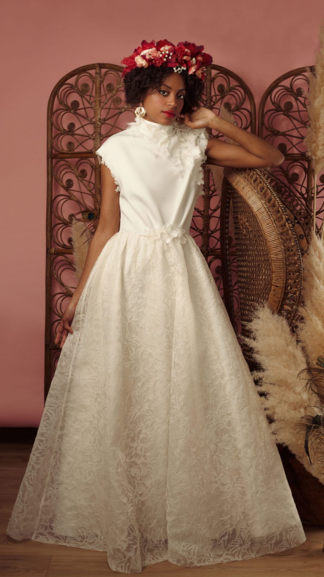 Femme debout en robe Maison Jasmée en organza brodé. Porte une couronne de fleurs Maison Jasmée